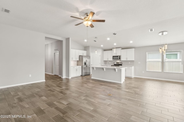 83687 Nether St, Fernandina Beach, FL 32034 - unfurnished living room with a ceiling fan, vaulted ceiling, light wood-type flooring, recessed lighting, and a chandelier