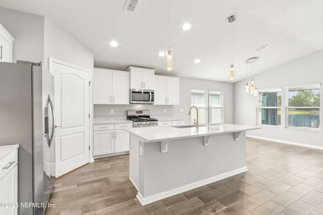 83687 Nether St, Fernandina Beach, FL 32034 - kitchen with stainless steel appliances, light countertops, light wood-type flooring, lofted ceiling, and a kitchen breakfast bar