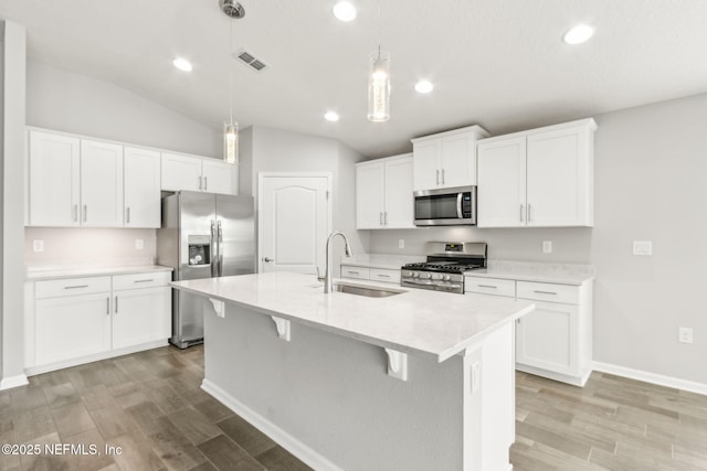83687 Nether St, Fernandina Beach, FL 32034 - kitchen with appliances with stainless steel finishes, recessed lighting, light wood-style flooring, a center island with sink, and decorative light fixtures