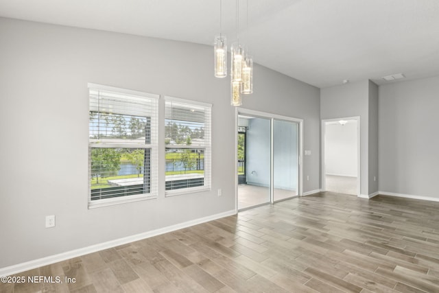 83687 Nether St, Fernandina Beach, FL 32034 - empty room featuring light wood-style flooring, a chandelier, and a water view