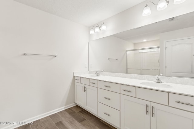 83687 Nether St, Fernandina Beach, FL 32034 - bathroom with double vanity, a shower stall, and wood finished floors
