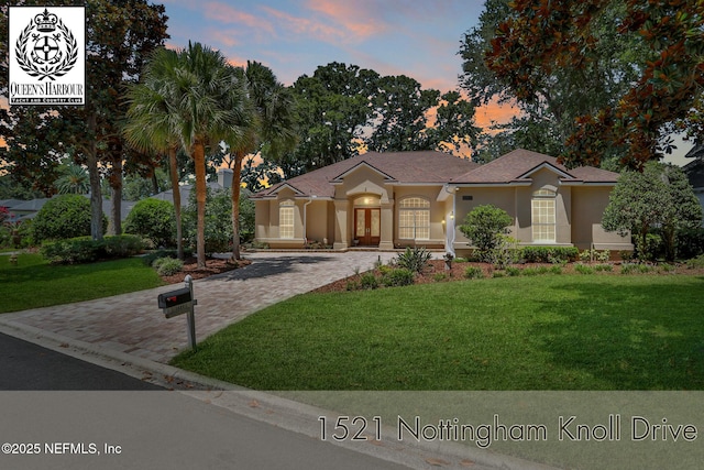 1521 Nottingham Knoll Dr, Jacksonville, FL 32225 - view of front of property featuring stucco siding, a lawn, driveway, and french doors