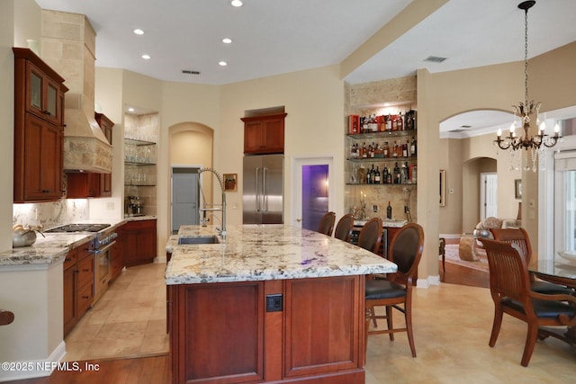 1521 Nottingham Knoll Dr, Jacksonville, FL 32225 - kitchen with high end appliances, arched walkways, tasteful backsplash, a kitchen bar, and light stone countertops