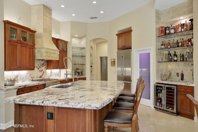 1521 Nottingham Knoll Dr, Jacksonville, FL 32225 - kitchen with beverage cooler, high end refrigerator, arched walkways, light stone counters, and backsplash