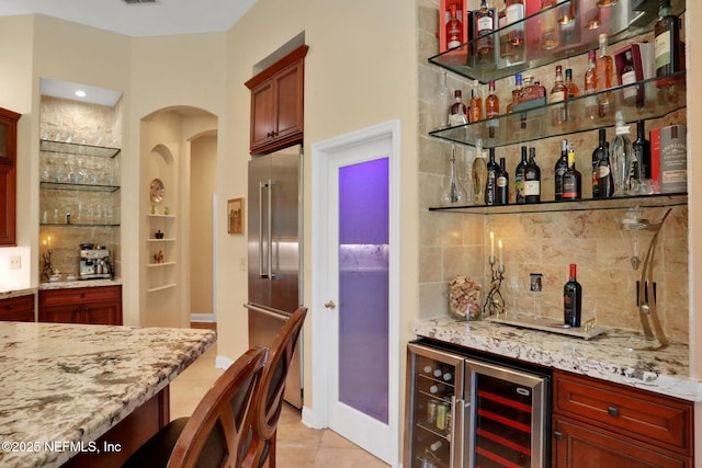 1521 Nottingham Knoll Dr, Jacksonville, FL 32225 - indoor dry bar featuring beverage cooler, high quality fridge, decorative backsplash, light tile patterned floors, and arched walkways