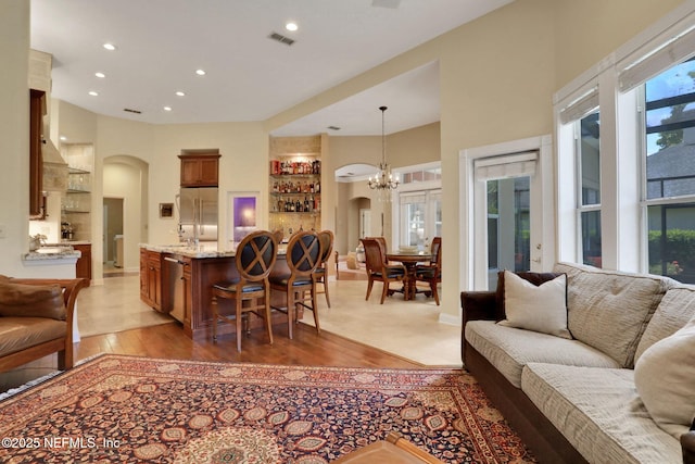 1521 Nottingham Knoll Dr, Jacksonville, FL 32225 - living area featuring arched walkways, light wood-style flooring, recessed lighting, and a chandelier
