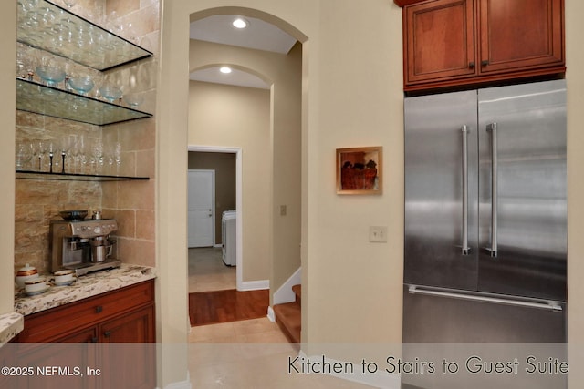 1521 Nottingham Knoll Dr, Jacksonville, FL 32225 - kitchen with high quality fridge, arched walkways, light stone counters, light tile patterned floors, and recessed lighting