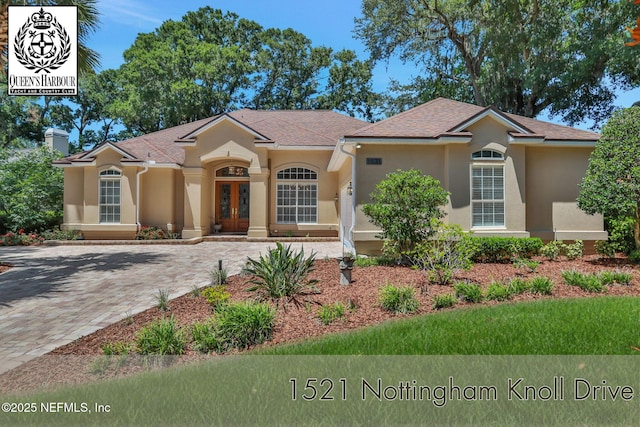 1521 Nottingham Knoll Dr, Jacksonville, FL 32225 - view of front of property featuring stucco siding, french doors, driveway, and roof with shingles