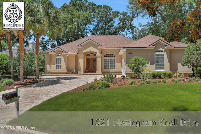 1521 Nottingham Knoll Dr, Jacksonville, FL 32225 - view of front facade featuring stucco siding, a front lawn, french doors, and driveway