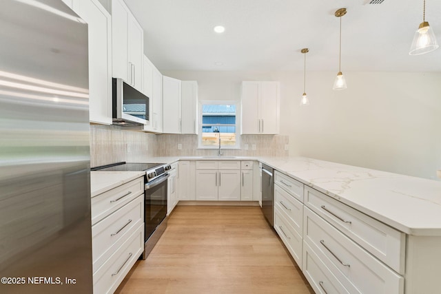 981 Butler Ave, Saint Augustine, FL 32084 - kitchen with stainless steel appliances, a peninsula, backsplash, white cabinets, and recessed lighting
