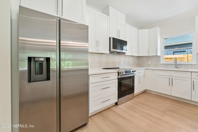 981 Butler Ave, Saint Augustine, FL 32084 - kitchen featuring stainless steel appliances, light wood-style flooring, light countertops, and white cabinetry