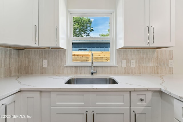 981 Butler Ave, Saint Augustine, FL 32084 - kitchen featuring white cabinetry, decorative backsplash, and light stone countertops
