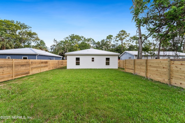 981 Butler Ave, Saint Augustine, FL 32084 - rear view of house with a metal roof and a fenced backyard