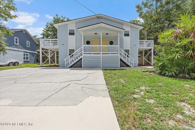631-633 Main St, Atlantic Beach, FL 32233 - coastal inspired home featuring stairs, covered porch, and a front yard