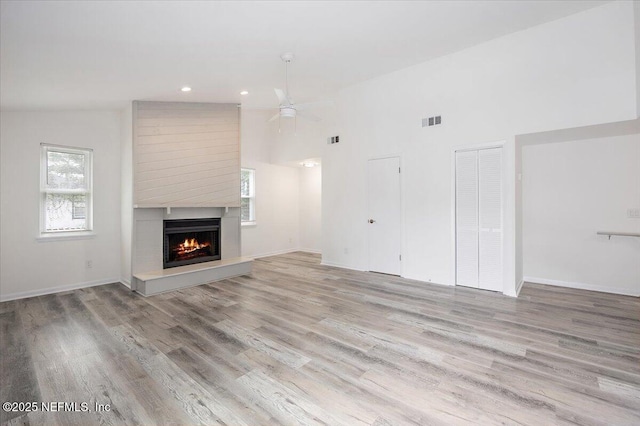 631-633 Main St, Atlantic Beach, FL 32233 - unfurnished living room with light wood-style flooring, ceiling fan, a lit fireplace, recessed lighting, and high vaulted ceiling