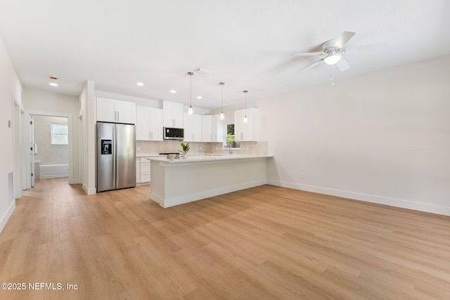 989 Butler Ave, Saint Augustine, FL 32084 - kitchen with stainless steel appliances, a peninsula, light countertops, backsplash, and light wood-style floors