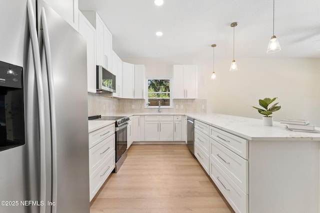 989 Butler Ave, Saint Augustine, FL 32084 - kitchen with stainless steel appliances, tasteful backsplash, a peninsula, white cabinetry, and recessed lighting