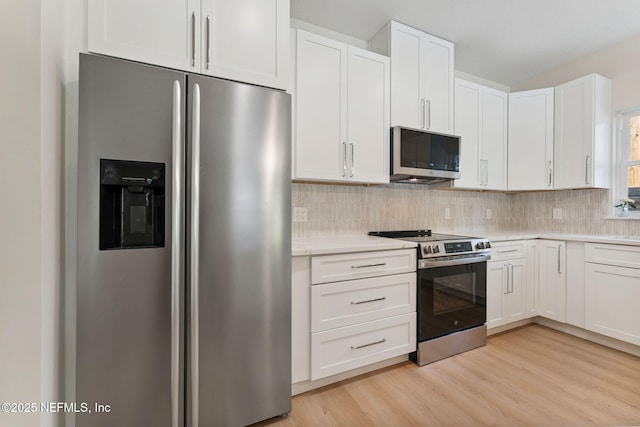 989 Butler Ave, Saint Augustine, FL 32084 - kitchen featuring appliances with stainless steel finishes, light countertops, decorative backsplash, light wood-style flooring, and white cabinets