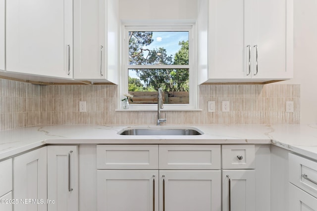 989 Butler Ave, Saint Augustine, FL 32084 - kitchen with white cabinets, decorative backsplash, and light stone counters