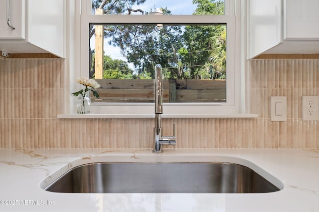 989 Butler Ave, Saint Augustine, FL 32084 - kitchen view of backsplash, white cabinetry, and light stone countertops