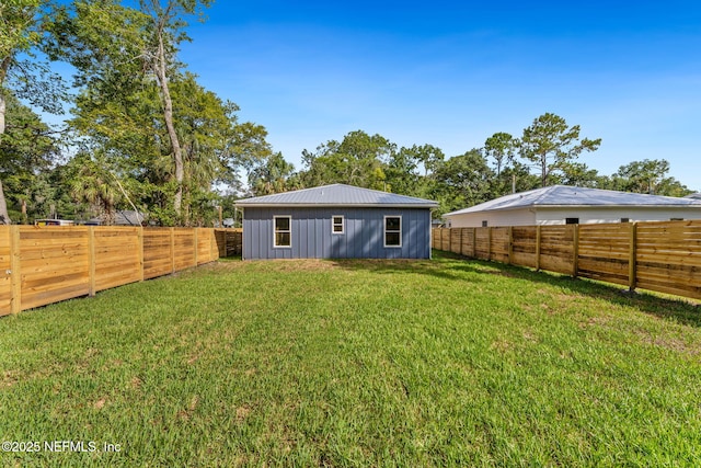 989 Butler Ave, Saint Augustine, FL 32084 - rear view of property featuring board and batten siding, a fenced backyard, and a metal roof