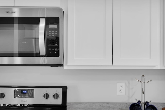 724 N Pine Ave, Green Cove Springs, FL 32043 - kitchen view of stainless steel microwave, white cabinetry, and stove