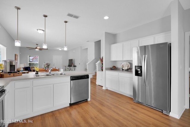 724 N Pine Ave, Green Cove Springs, FL 32043 - kitchen with stainless steel appliances, open floor plan, a ceiling fan, light wood-style floors, and white cabinets