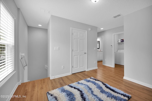 724 N Pine Ave, Green Cove Springs, FL 32043 - bedroom featuring wood finished floors, washer / dryer, a textured ceiling, and recessed lighting