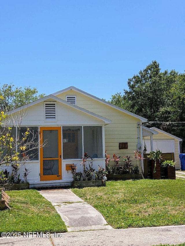 217 Covino Ave, Saint Augustine, FL 32084 - view of front of house featuring a sunroom and a front yard