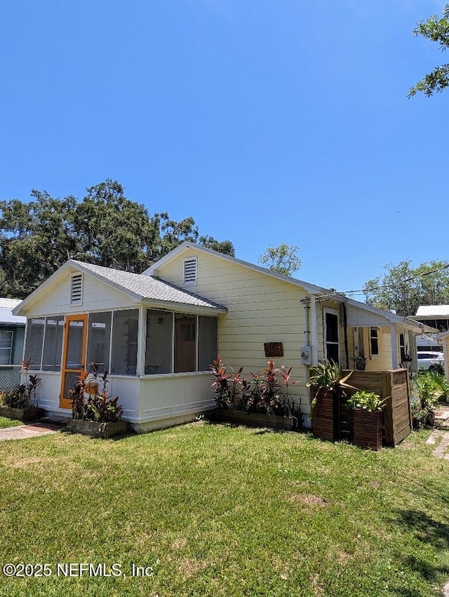 217 Covino Ave, Saint Augustine, FL 32084 - view of front facade featuring a sunroom and a front lawn