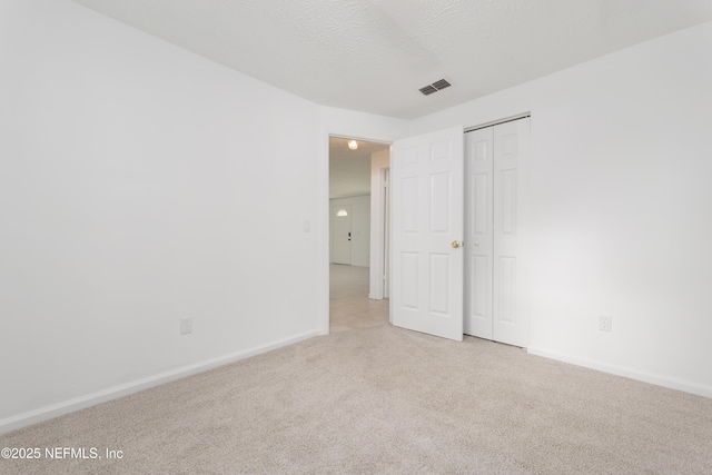 175 Evergreen Ln, Middleburg, FL 32068 - unfurnished bedroom with light colored carpet, a textured ceiling, and a closet