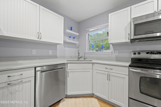 1419 Linkside Dr, Atlantic Beach, FL 32233 - kitchen with appliances with stainless steel finishes, light countertops, white cabinets, and light wood-style floors