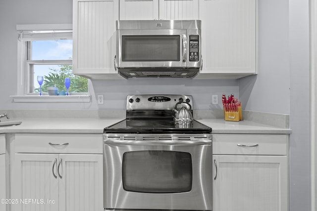 1419 Linkside Dr, Atlantic Beach, FL 32233 - kitchen with appliances with stainless steel finishes, white cabinetry, and light countertops