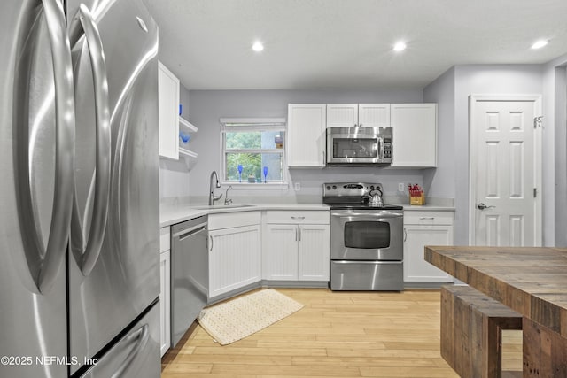 1419 Linkside Dr, Atlantic Beach, FL 32233 - kitchen featuring appliances with stainless steel finishes, white cabinets, light countertops, recessed lighting, and light wood-style flooring