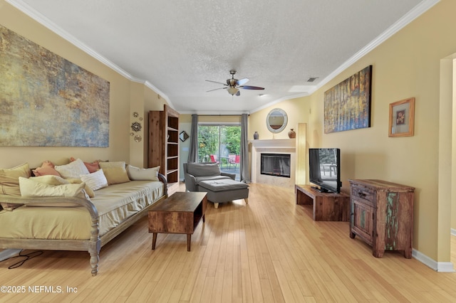 1419 Linkside Dr, Atlantic Beach, FL 32233 - living room featuring a ceiling fan, ornamental molding, a glass covered fireplace, light wood-style flooring, and a textured ceiling