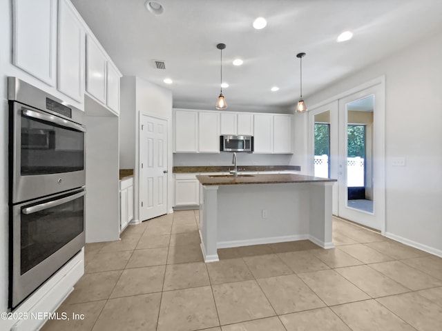 1090 Lauriston Dr, Saint Johns, FL 32259 - kitchen with appliances with stainless steel finishes, light tile patterned floors, white cabinets, an island with sink, and recessed lighting
