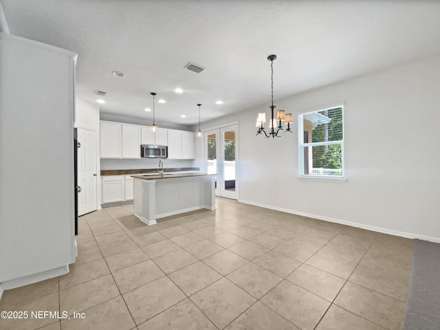 1090 Lauriston Dr, Saint Johns, FL 32259 - kitchen featuring stainless steel microwave, light tile patterned flooring, dark countertops, recessed lighting, and white cabinetry