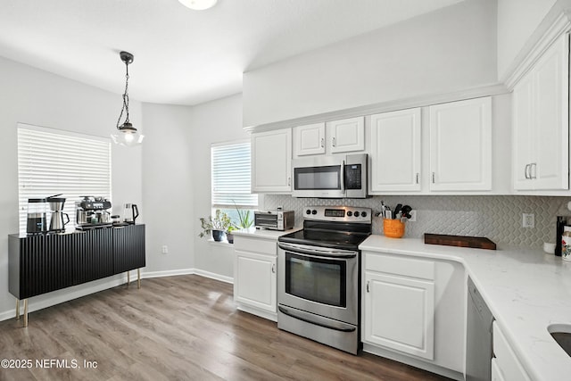 14410 Pelican Bay Ct, Jacksonville, FL 32224 - kitchen with appliances with stainless steel finishes, tasteful backsplash, and white cabinets