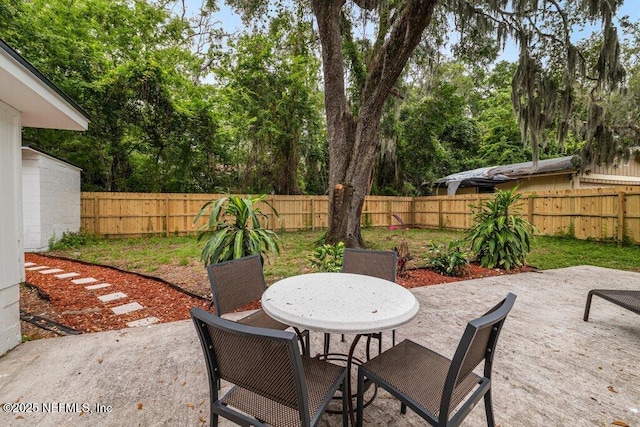 2571 Montreal St, Jacksonville, FL 32233 - fenced backyard featuring a patio area, outdoor dining area, and view of wooded area