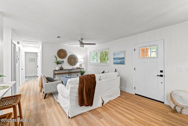 2571 Montreal St, Jacksonville, FL 32233 - living room featuring light wood-style flooring, a ceiling fan, and a textured ceiling