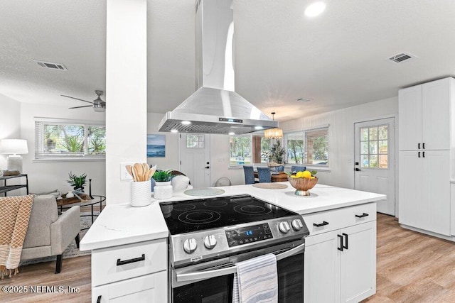 2571 Montreal St, Jacksonville, FL 32233 - kitchen featuring stainless steel electric stove, island range hood, open floor plan, and light wood-style floors