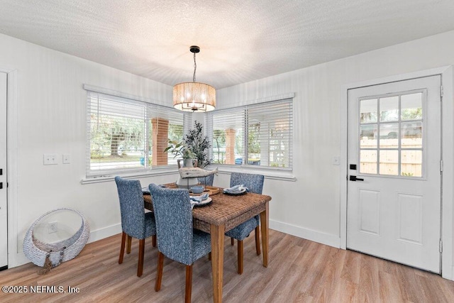 2571 Montreal St, Jacksonville, FL 32233 - dining area featuring a chandelier, light wood-type flooring, healthy amount of natural light, and a textured ceiling
