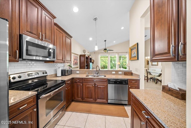 814 Copperhead Cir, Saint Augustine, FL 32092 - kitchen featuring stainless steel appliances, backsplash, light stone countertops, vaulted ceiling, and light tile patterned flooring