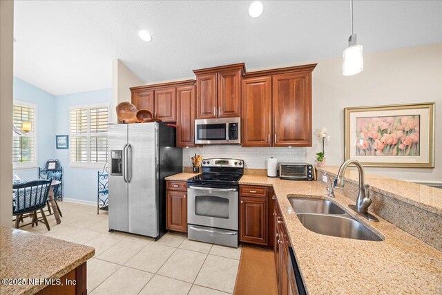 814 Copperhead Cir, Saint Augustine, FL 32092 - kitchen featuring appliances with stainless steel finishes, vaulted ceiling, backsplash, light tile patterned flooring, and pendant lighting