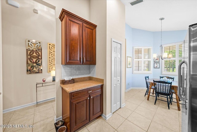 814 Copperhead Cir, Saint Augustine, FL 32092 - kitchen with a chandelier, stainless steel refrigerator, light tile patterned floors, decorative backsplash, and a high ceiling