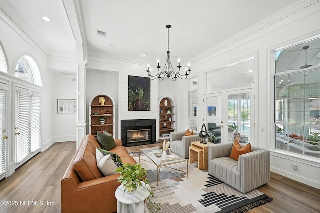 24237 Marsh Landing Pkwy, Ponte Vedra Beach, FL 32082 - living room with wood finished floors, a chandelier, a glass covered fireplace, ornamental molding, and recessed lighting