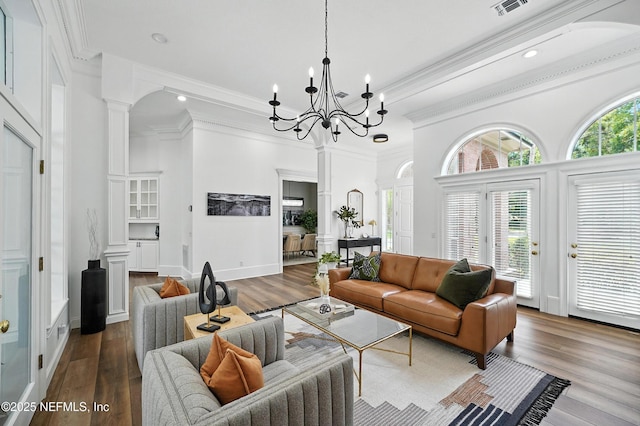 24237 Marsh Landing Pkwy, Ponte Vedra Beach, FL 32082 - living area with decorative columns, wood finished floors, crown molding, a chandelier, and a towering ceiling