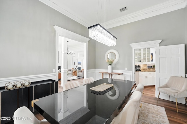 24237 Marsh Landing Pkwy, Ponte Vedra Beach, FL 32082 - dining space with a chandelier, ornamental molding, wood finished floors, wainscoting, and a decorative wall