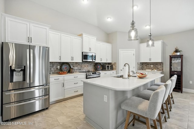 29 Lagoon Way, Palm Coast, FL 32137 - kitchen with appliances with stainless steel finishes, backsplash, light countertops, white cabinetry, and a kitchen bar