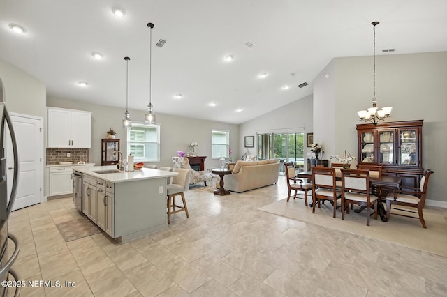 29 Lagoon Way, Palm Coast, FL 32137 - kitchen featuring stainless steel dishwasher, plenty of natural light, a chandelier, high vaulted ceiling, and open floor plan